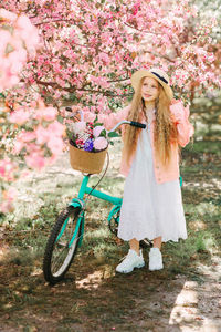 Woman standing by pink flowering plant