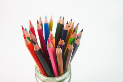 Close-up of multi colored pencils against white background