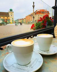 Close-up of coffee on table against building in city