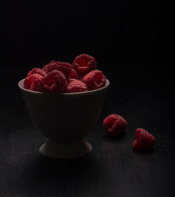 Close-up of fruits served on table against black background