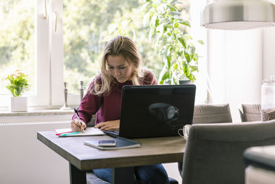 Female teenager studying at home