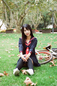 Portrait of young woman sitting on field