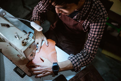 Midsection of man working in workshop