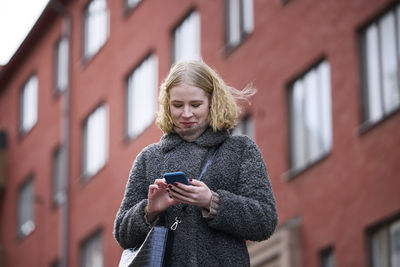 Smiling woman using cell phone