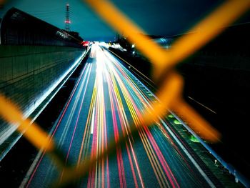 Light trails on chainlink fence at night