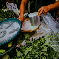 Midsection of man preparing food at market stall