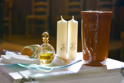 Items prepared on a table for a baptism ceremony in a church, backlit by the sun