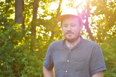 Mid adult man standing against trees