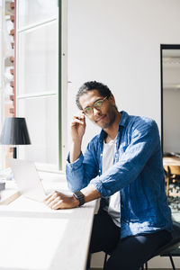 Portrait of male computer programmer sitting at desk in office