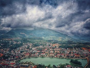 Aerial view of town by river against sky