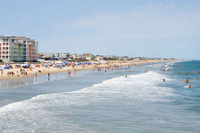 People at beach against blue sky