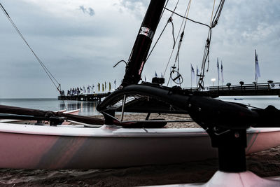 Boats moored at harbor against sky