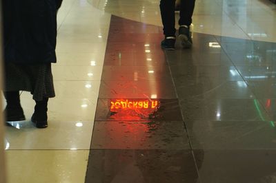 Low section of men standing on tiled floor