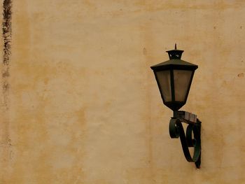 Low angle view of lamp post against wall