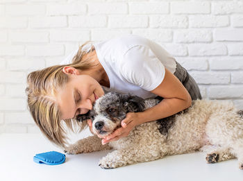 Woman with dog against wall