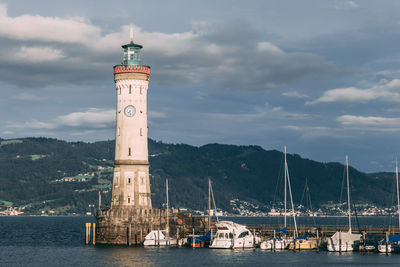 Lighthouse by sea against sky