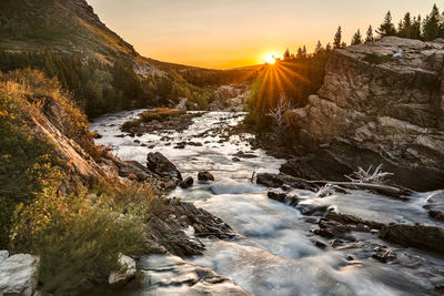 Scenic view of stream against sky during sunset