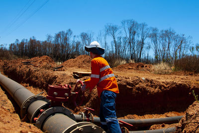 Man working on field against clear sky