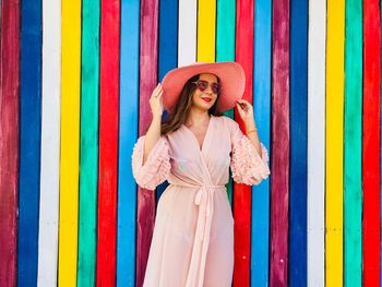 Woman in dress standing against multi colored wall