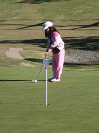 Full length of a man holding umbrella on golf course