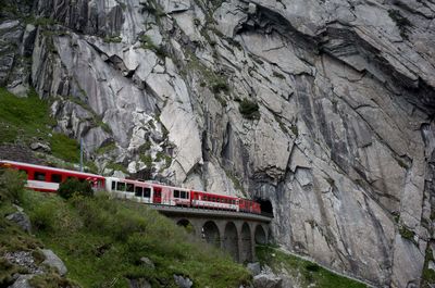 Train  passing by a rock formation in switzerland 