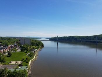 High angle view of river by buildings against blue sky