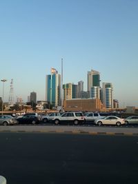 View of city street and buildings against clear sky