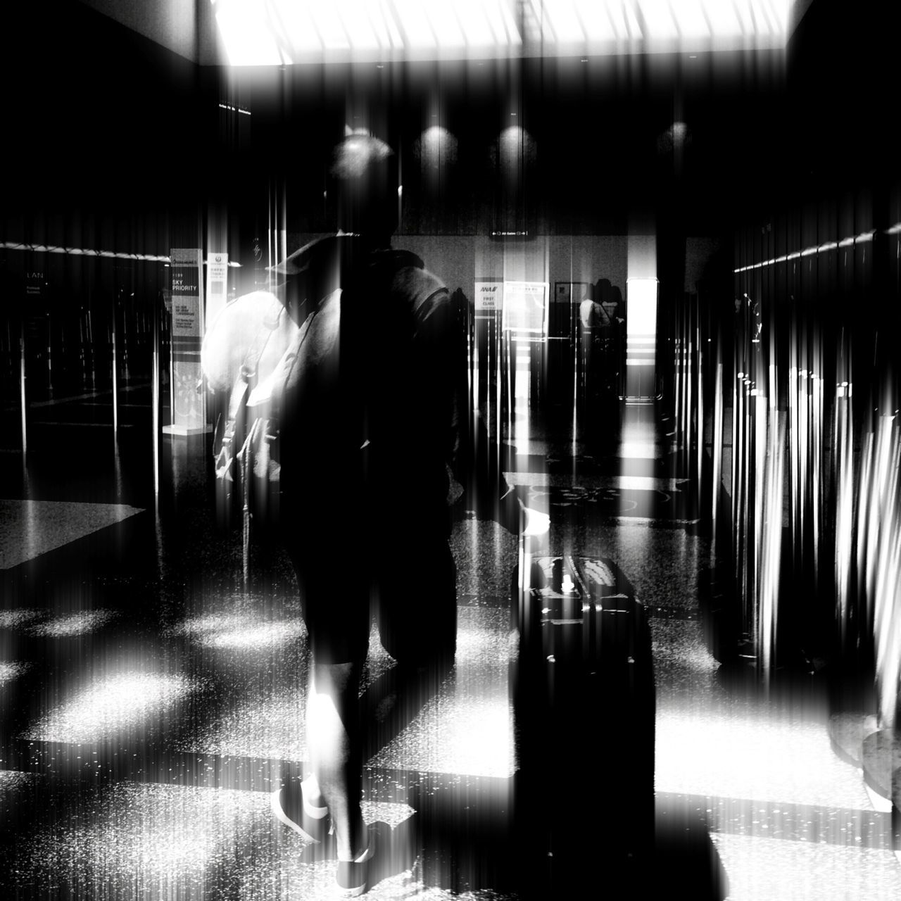 indoors, illuminated, men, lifestyles, walking, person, full length, reflection, night, rear view, leisure activity, flooring, silhouette, standing, blurred motion, built structure, architecture