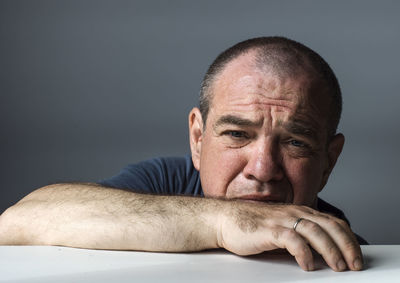 Portrait of man wearing hat against gray background