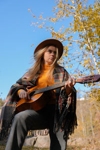 Portrait of young woman standing against sky