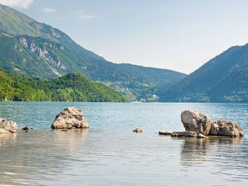 Stones stack on shore of blue green mountain lake molveno. village molveno. brenta dolomites, italy.