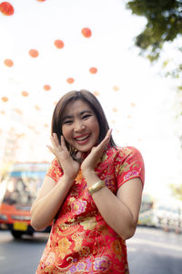 Portrait of smiling woman standing on road