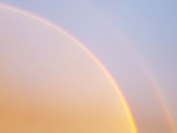 Low angle view of rainbow against sky at sunset