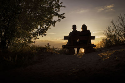 Silhouette couple looking at sunset