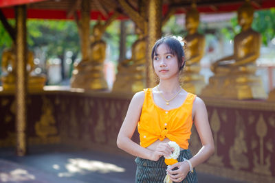 Portrait of young woman standing in city