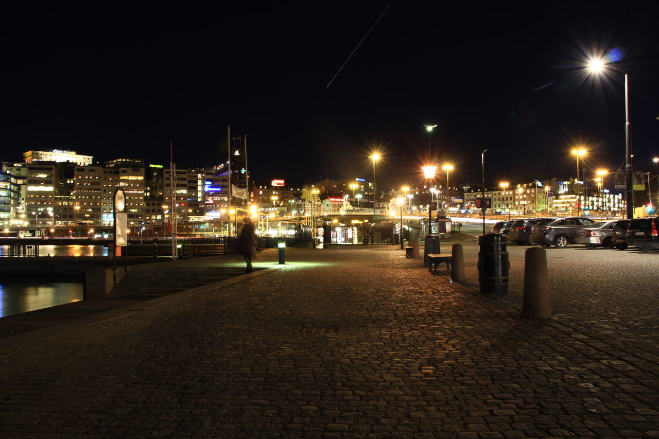 illuminated, night, building exterior, city, architecture, built structure, street light, transportation, street, lighting equipment, the way forward, sky, city life, mode of transport, clear sky, outdoors, nautical vessel, empty, cityscape, river