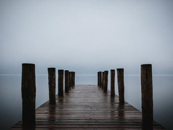 Wooden pier on sea against sky