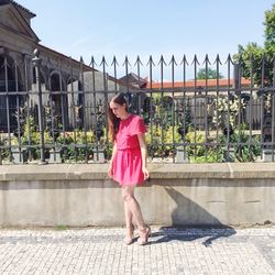 Full length of woman on pink umbrella