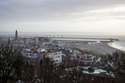 High angle view of townscape by sea against sky