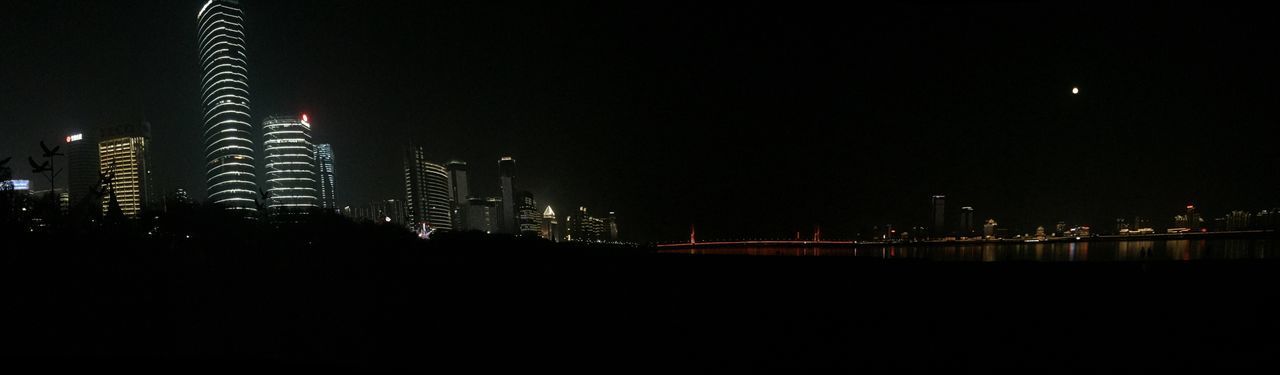 night, illuminated, city, architecture, built structure, building exterior, copy space, dark, clear sky, skyscraper, cityscape, modern, river, lighting equipment, urban skyline, development, tall - high, bridge - man made structure, street light, sky