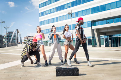 Friends dancing against building in city