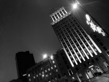 Low angle view of illuminated buildings against sky at night