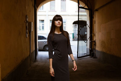 Full length portrait of woman standing in corridor