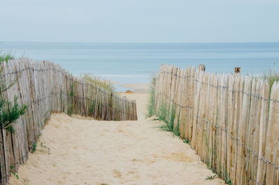 Sandy pathway leading to calm sea