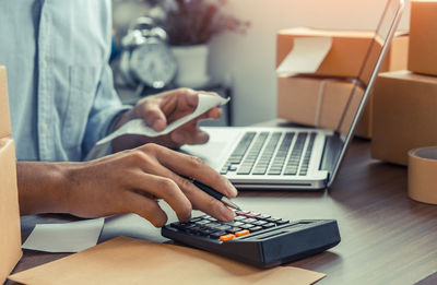 Midsection of man using laptop on table