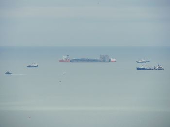 Boats sailing on sea against clear sky