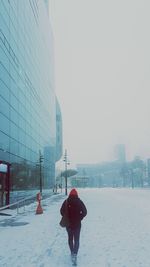 Man standing on snow covered cityscape