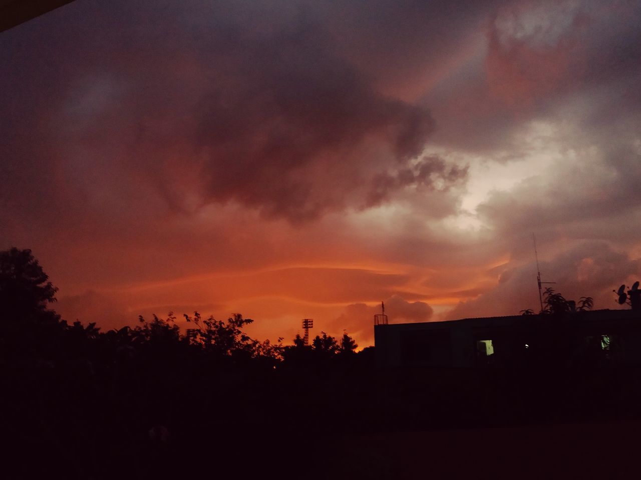 SILHOUETTE BUILDINGS AGAINST DRAMATIC SKY AT SUNSET