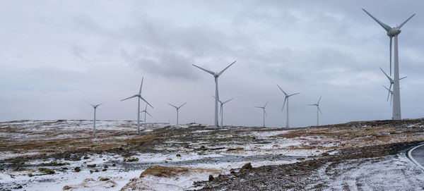 Windmills against sky during winter