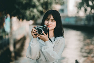 Portrait of young woman photographing